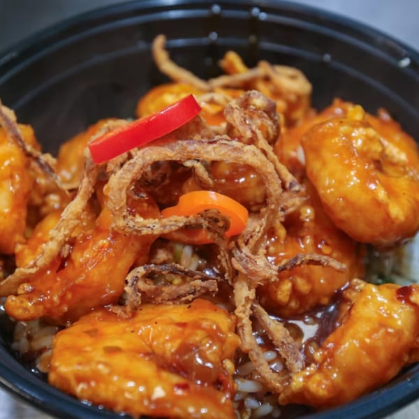 Bobby Wong's sweet and sour chicken with crispy onions and red pepper slices over rice.
